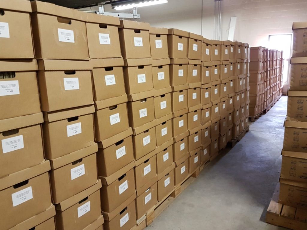 Image of the ANES archive: A hallway full of brown boxes stacked in towers.